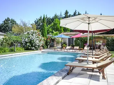a swimming pool with chairs and an umbrella at Holiday Home L'Olivier by Interhome in Lagnes