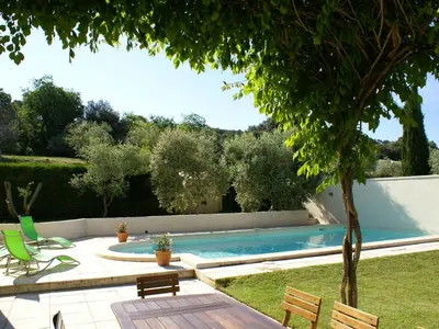 a swimming pool in a yard with chairs and a tree at Holiday Home Clos Saint Joseph by Interhome in Lagnes