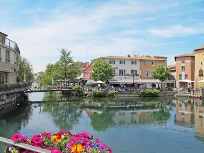 a river in a town with a bridge and flowers at Holiday Home Clos Saint Joseph by Interhome in Lagnes