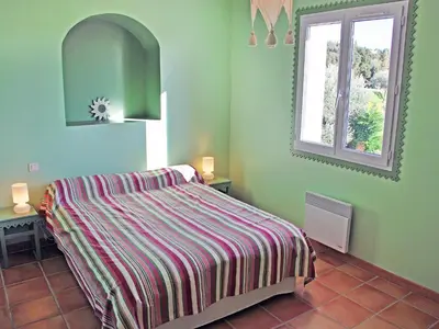 a green bedroom with a bed and a window at Holiday Home Clos Saint Joseph by Interhome in Lagnes