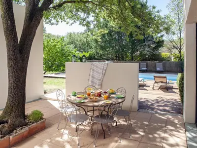 a table and chairs on a patio next to a tree at Holiday Home Villa Isabelle by Interhome in Gondonnets