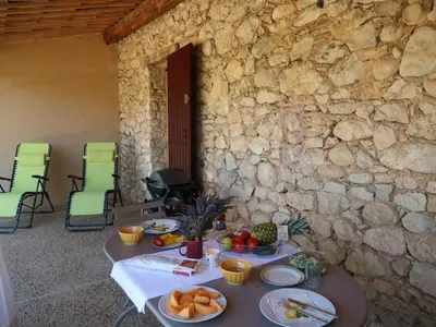 a table with plates of fruit on a stone wall at Holiday Home Les Geais by Interhome in Saint-Saturnin-les-Apt