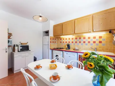 a kitchen with a white table with a vase of flowers at Holiday Home Les Ecureuils by Interhome in Saint-Pantaléon