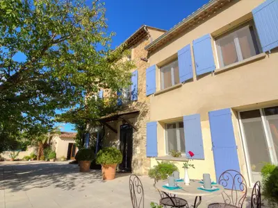 a table and chairs in front of a building at Holiday Home de la Roque by Interhome in Althen-des-Paluds