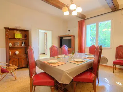 a dining room with a table and red chairs at Holiday Home de la Roque by Interhome in Althen-des-Paluds