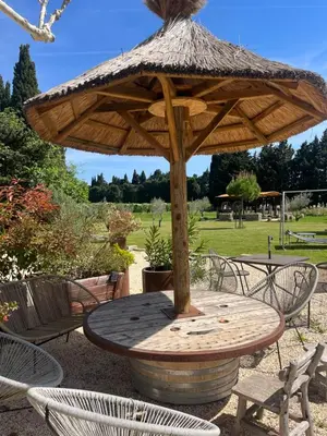 a wooden table with a umbrella on top of it at Mas de Nonin St Rémy de Provence in Noves