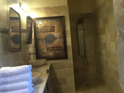 a bathroom with two sinks and two mirrors at Mas de Nonin St Rémy de Provence in Noves