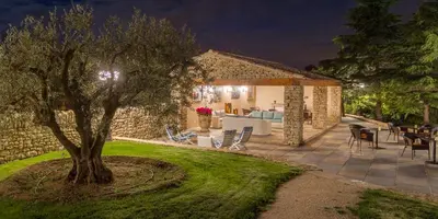 a stone house with a courtyard at night at Le Jas de Gordes in Gordes