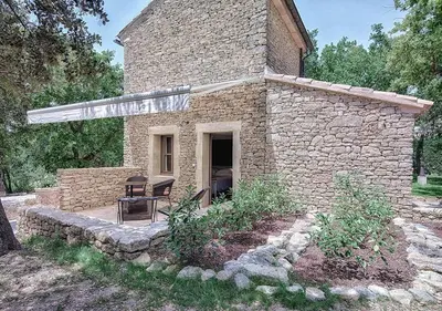 a stone building with a patio and a table at Le Jas de Gordes in Gordes