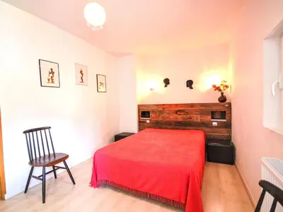 a bedroom with a red bed and a chair at Holiday Home La Croix du Puits by Interhome in Robion en Luberon