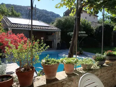 a row of potted plants on a wall next to a pool at Holiday Home La Croix du Puits by Interhome in Robion en Luberon