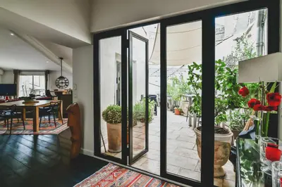 a living room with sliding glass doors and a dining room at Escapade en Provence in LʼIsle-sur-la-Sorgue