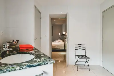 a bathroom with a sink and a chair at Escapade en Provence in LʼIsle-sur-la-Sorgue