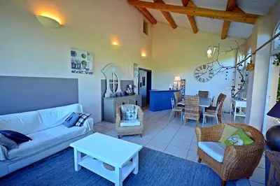a living room with a couch and a table at Gîte Crillon - Mas Les Fleurs d'Hilaire in Monteux