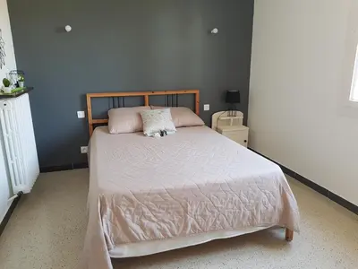 a bedroom with a bed with pink sheets and pillows at Location maison Monteux in Monteux