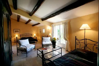 a living room with two beds a table and a couch at La Ferme in Saint-Marc-Jaumegarde