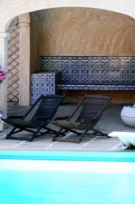 two lounge chairs sitting next to a swimming pool at La Ferme in Saint-Marc-Jaumegarde