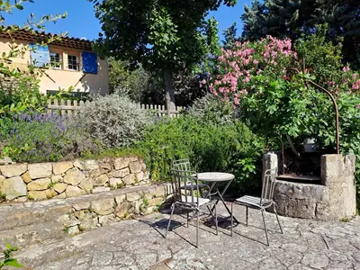 two chairs and a table in a garden at La Ferme in Saint-Marc-Jaumegarde