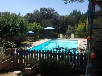 a swimming pool in a yard with a fence at L'OLIVERAIE EN PROVENCE in Lambesc