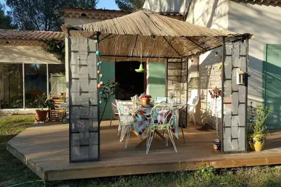 a wooden deck with a table and chairs on it at L'OLIVERAIE EN PROVENCE in Lambesc