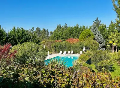 a swimming pool with blue water in a resort at Mas Les Fleurs d’Hilaire in Monteux