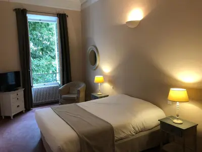 a bedroom with a bed and a window with a chair at Le Couvent in Apt