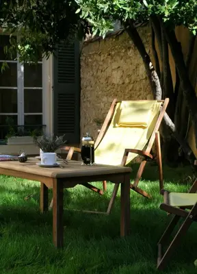 a picnic table and a chair sitting in the grass at Le Couvent in Apt