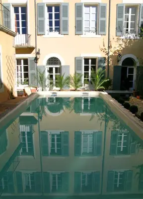 a swimming pool in front of a building at Le Couvent in Apt