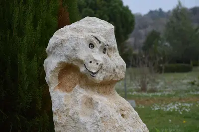 a statue of a rock with a face on it at La Bastide des Raisins in Apt