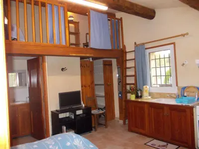 a bedroom with a bunk bed and a bathroom at La Bastide des Raisins in Apt