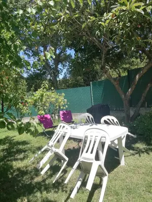two white chairs and a table in the grass at Sophie et Jamiel in Eyragues