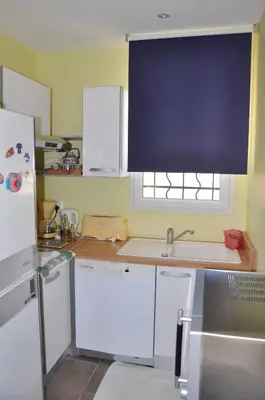 a kitchen with white cabinets and a sink and a window at Martichris in Châteauneuf-de-Gadagne