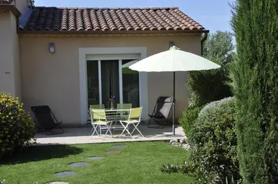 a patio with a table and chairs and an umbrella at Martichris in Châteauneuf-de-Gadagne