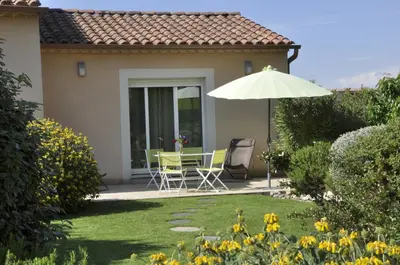 a patio with a table and chairs and an umbrella at Martichris in Châteauneuf-de-Gadagne