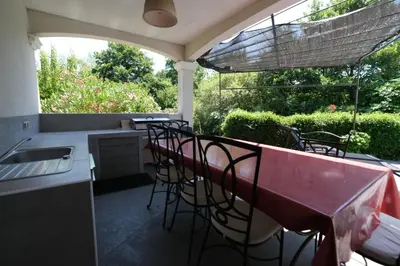 a patio with a table and chairs and a kitchen at charming family house with pool located at L'isle sur la sorgue - sleeps 8 in LʼIsle-sur-la-Sorgue