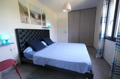 a bedroom with a bed and a red chair at charming family house with pool located at L'isle sur la sorgue - sleeps 8 in LʼIsle-sur-la-Sorgue