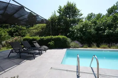 a swimming pool with chairs and an umbrella at charming family house with pool located at L'isle sur la sorgue - sleeps 8 in LʼIsle-sur-la-Sorgue