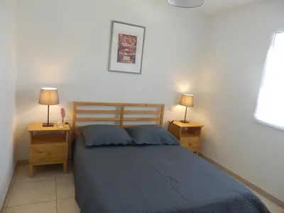 a bedroom with a bed and two night stands with lamps at La Maison Bougnette in Flassan