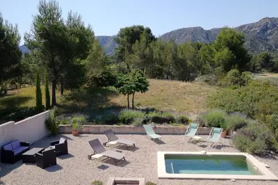 a group of lounge chairs and a swimming pool at Le Mas des Genets in Saint-Rémy-de-Provence