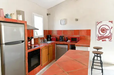 a kitchen with orange tiles and a white refrigerator at Le Mas des Genets in Saint-Rémy-de-Provence