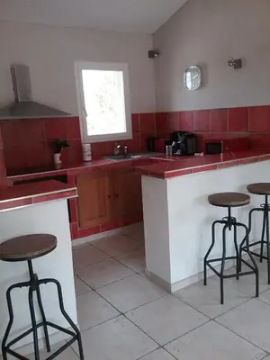 a kitchen with red counter tops and bar stools at Le Mas des Genets in Saint-Rémy-de-Provence
