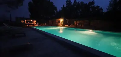 a swimming pool lit up at night at gîte Mas Antinea in Mazan