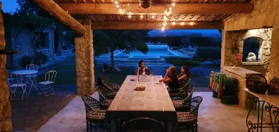 a group of people sitting at a table in a patio at gîte Mas Antinea in Mazan