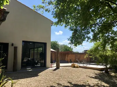a house with a large glass door in a yard at Villa en campagne avec piscine et jacuzzi in Aix-en-Provence
