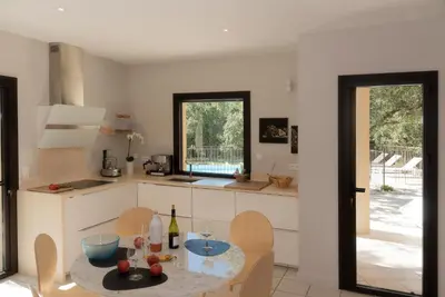 a kitchen with a table and chairs and a dining room at Maison atypique en Provence chez Brigitte in LʼIsle-sur-la-Sorgue
