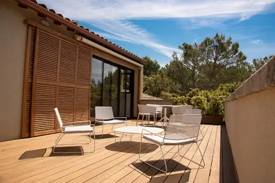 a deck with white chairs and a table on it at Maison atypique en Provence chez Brigitte in LʼIsle-sur-la-Sorgue