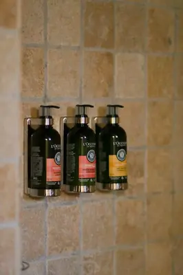 a group of four bottles of soap sitting on a shelf at LA FERME DE LA HUPPE in Gordes