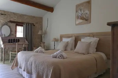 a bedroom with a large bed with towels on it at LA FERME DE LA HUPPE in Gordes