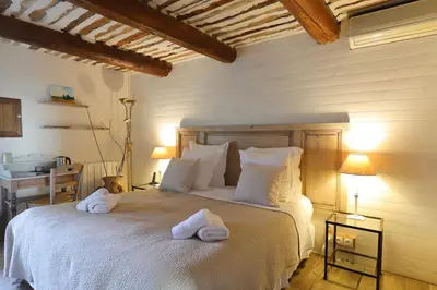 a bedroom with a bed with towels on it at LA FERME DE LA HUPPE in Gordes