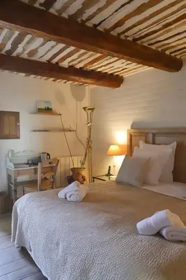 a bedroom with a bed with towels on it at LA FERME DE LA HUPPE in Gordes